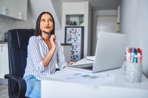 Cropped shot of a young businesswoman sitting at computer desk contemplating financial planning